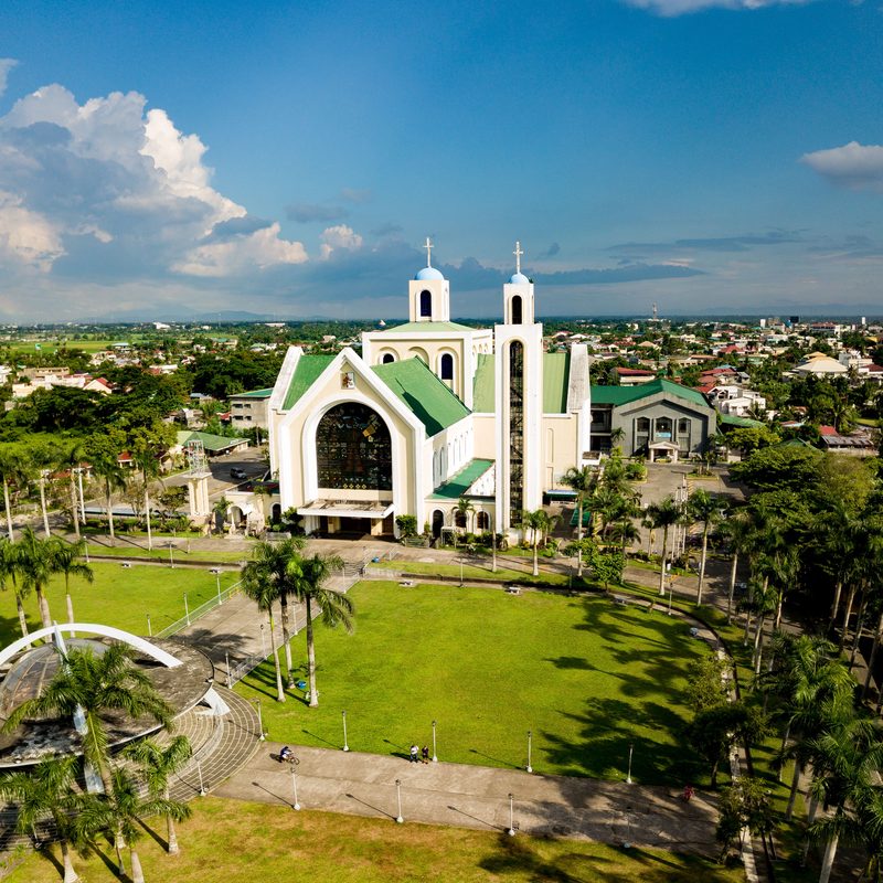 The Basilica Minore de Nuestra Se&ntilde;ora de Pe&ntilde;afrancia above its palm-lined grounds in Naga City.